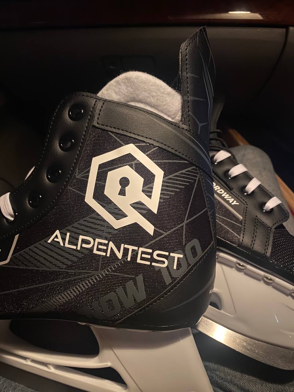 Black ice skate that shows the AlphaLock logo on the side in white
